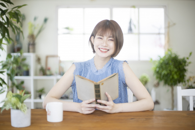 明るい部屋で読書する女性